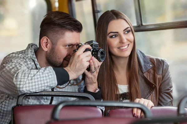 Two playful tourists taking fun photos from the bus on the film