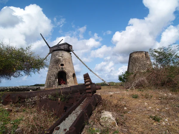 Old gears in front of an old windmill on Bettys Hope Plantation near Seatons, Pares on Antigua Barbuda in the Caribbean Lesser Antilles West Indies.