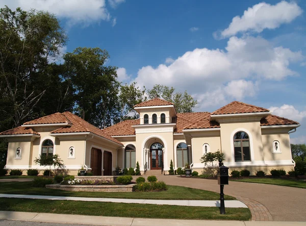 One story stucco residential home with a red clay tile roof and side garage.