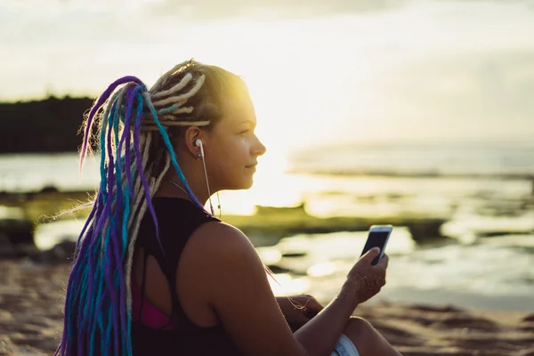 Hipster woman on the beach watching the sunset