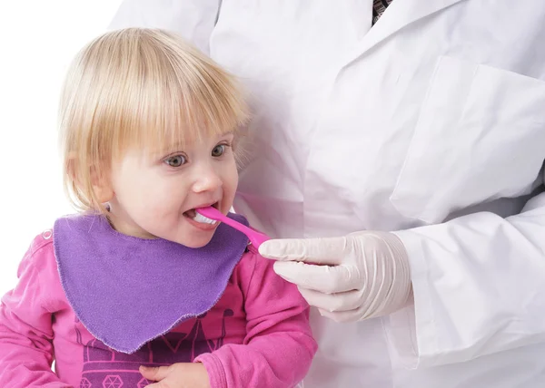 Baby girl gets help by the Dentist to brush her teeth