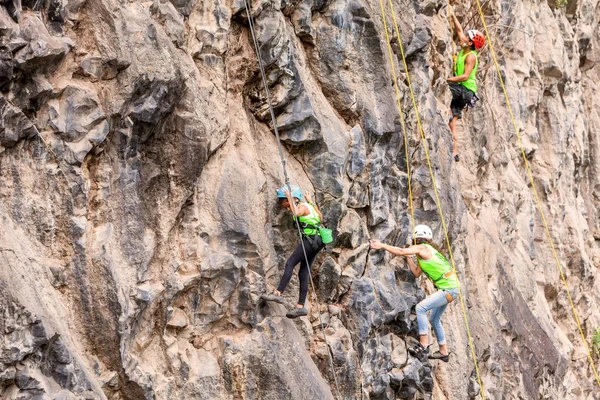 Team Of Climbers Climbing A Rock Wall