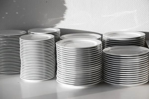 Several stacks of white porcelain plates