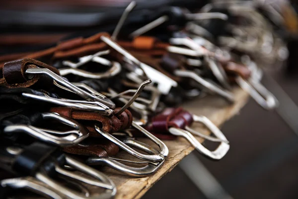Silver buckles of leather belts for sale at a flea market