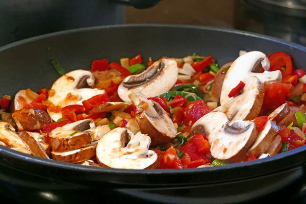 Stir fried vegetables in a black pan, close up