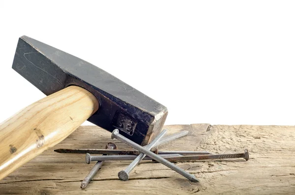 Hammer and nails on old wood, white background