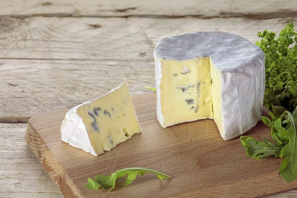Soft blue cheese from France  on a rustic wooden table