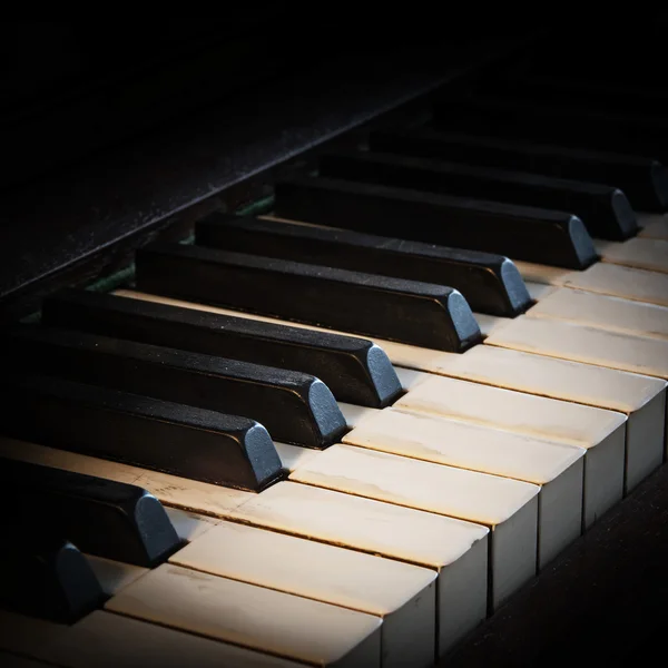 Antique piano keyboard fading into a black background, copy space