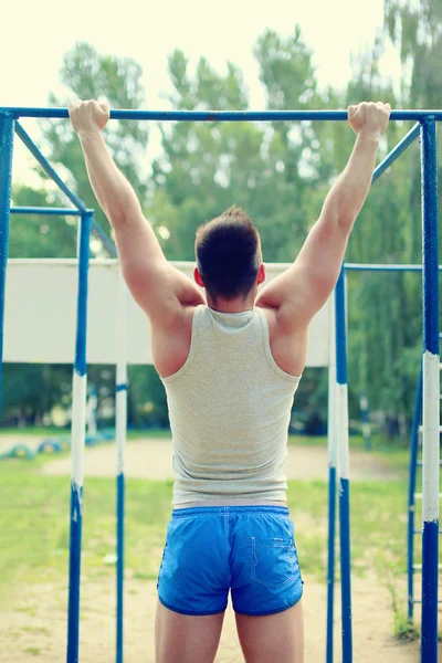 Workout sports man pull up on the horizontal bar