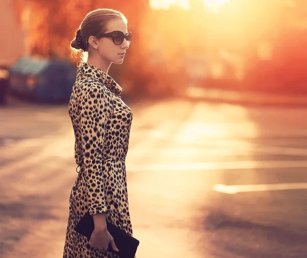 Street fashion, stylish woman in a dress with leopard print, eve