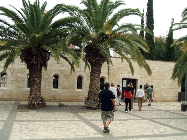 Entrance tourists visiting or entering the Church of the Multiplication, Tabgha, Israel