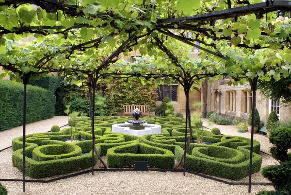 Knot garden with fountain through a vine arch,  Sudeley Castle,  Winchcombe, England