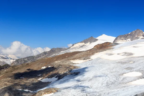 Mountain glacier panorama with summit Grossvenediger south face and alpine hut Defreggerhaus in the Hohe Tauern Alps, Austria