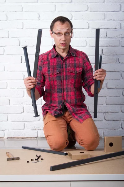 Young man confused about assembling furniture