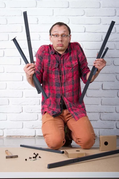 Young man confused about assembling furniture