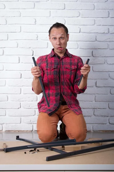 Young man confused about assembling furniture