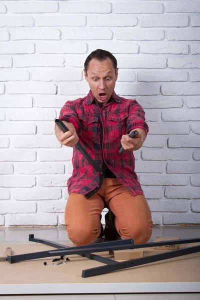 Young man confused about assembling furniture