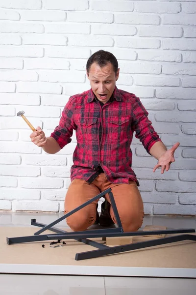 Young man confused about assembling furniture