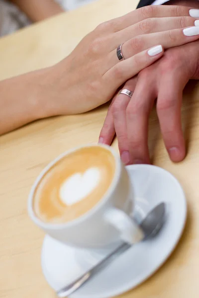 Cappuccino or latte coffee with heart shape. bride and groom drink a cup of Coffee latte on the date. Happy young bride and groom drink a cup of Coffee latte with heart design on their wedding day