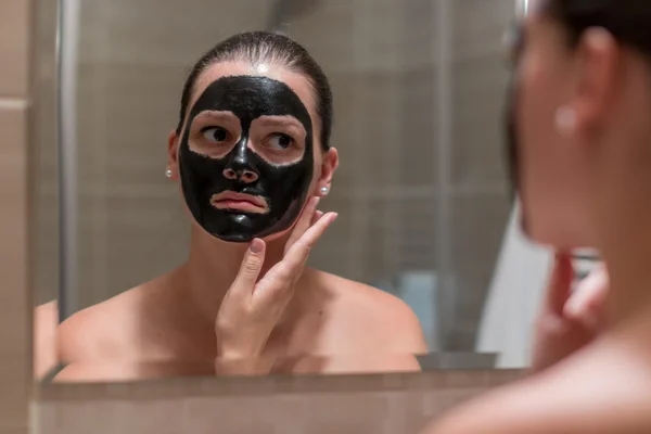 Young beautiful woman with a black mask for the face