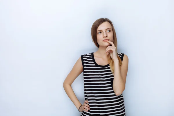 Portrait of happy young beautiful woman in striped shirt touching her lips posing for model tests against white studio background