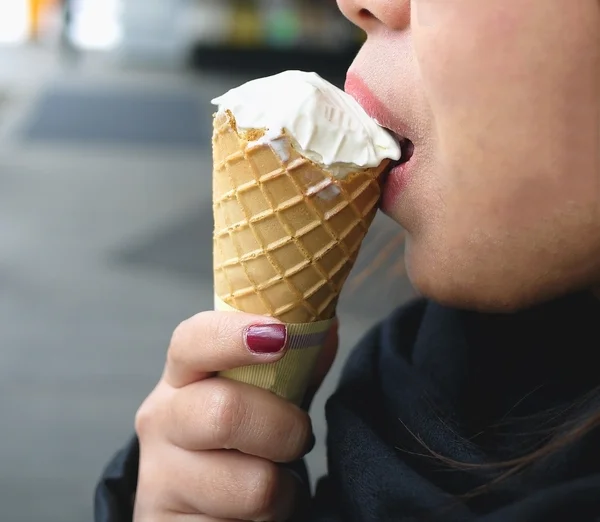 Half face of Asian woman eating Ice cream cone