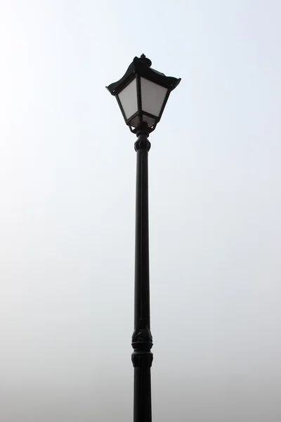Black street lamp post against the sky