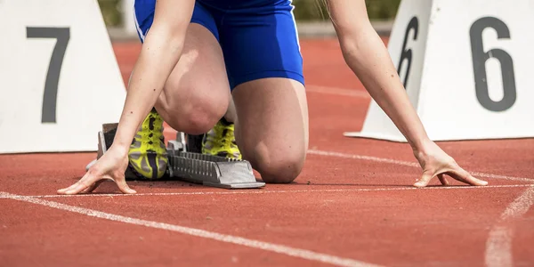 Woaman in sprintstart in track and field