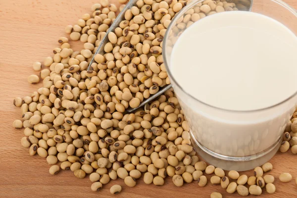 Soy milk in glass with soybeans and transfer scoop