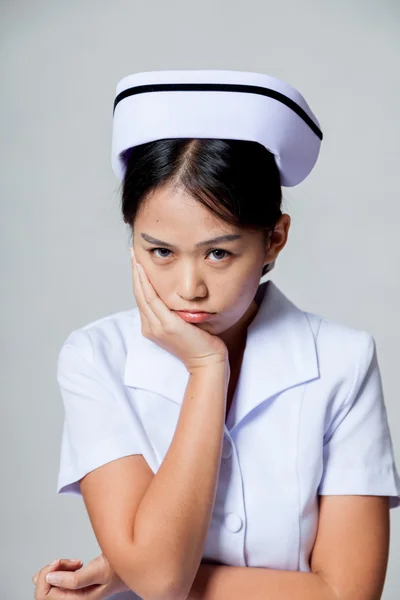 Young Asian nurse in bad mood