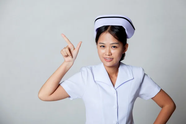 Young Asian nurse point to blank space