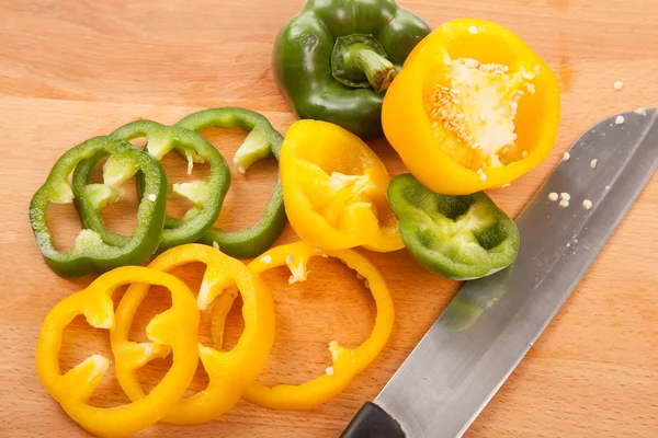 Cut yellow and green bell peppers on cutting board