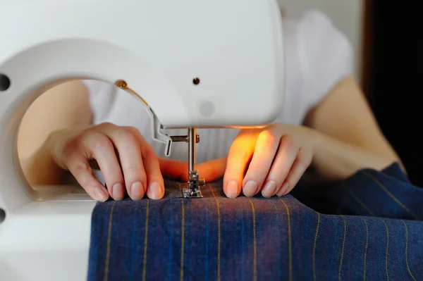 Tailoring of natural wool. Woman tailor working on sewing machin