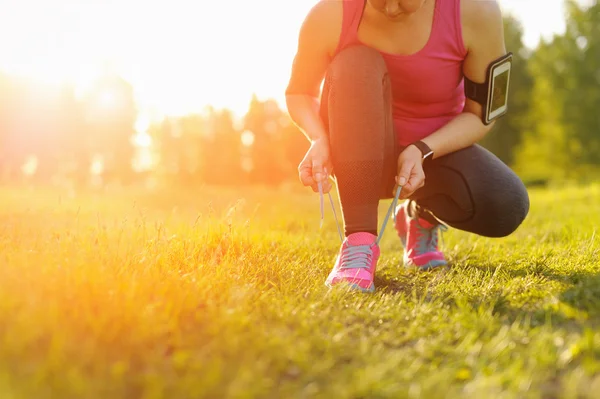 Woman lacing running shoes before workout.