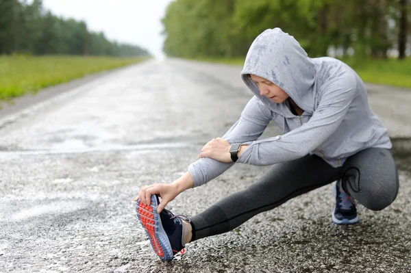 Running stretching in the rain.