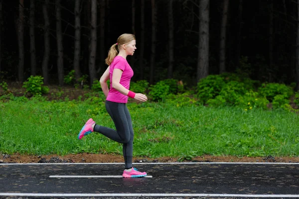 Runner woman running in Park in the rain. Jogging training for m