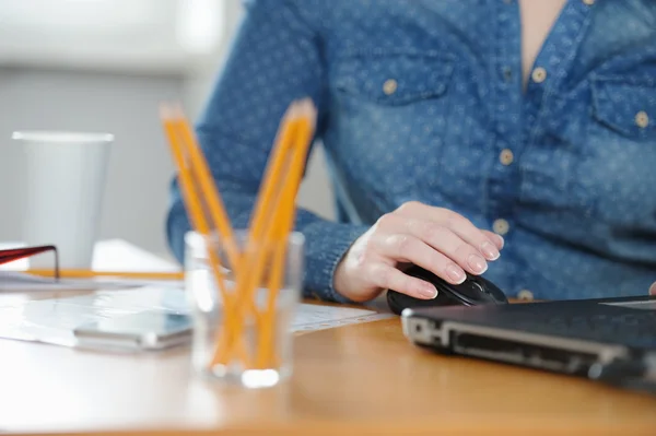 Freelancer woman working at computer while sitting at the table.