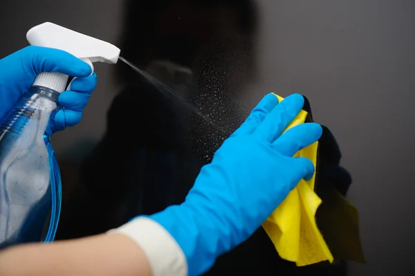 A woman\'s hands spraying liquid and wipe the dust off the TV.