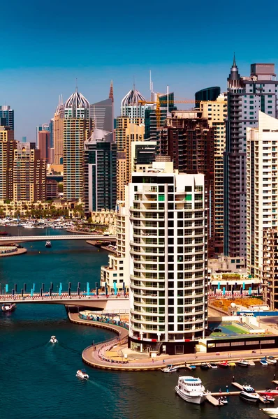 Amazing colorful dubai marina skyline with water canal and expensive yachts during sunny day, Dubai, United Arab Emirates.
