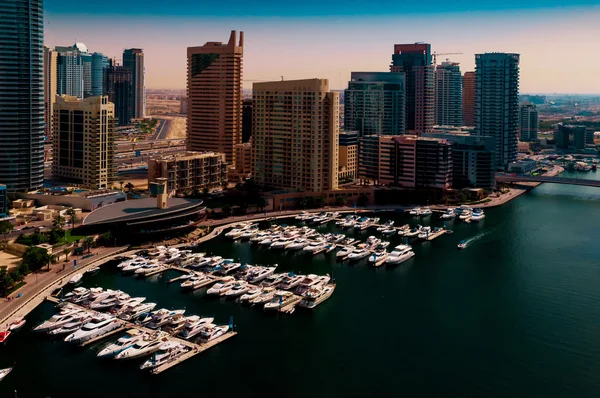 Amazing colorful dubai marina skyline with water canal and expensive yachts during sunny day, Dubai, United Arab Emirates.