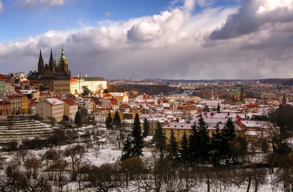 Amazing St. Vitus cathedral during winter day after heavy snow storm with snow cover at roofs. Sunny winter day in Hradcany district, Prague, Czech republic.