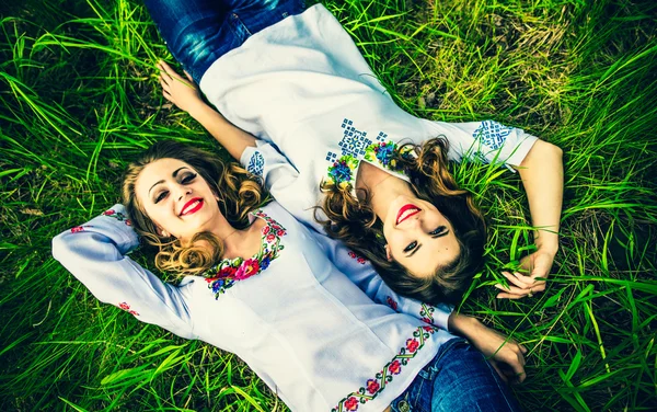Girls lying on the green grass