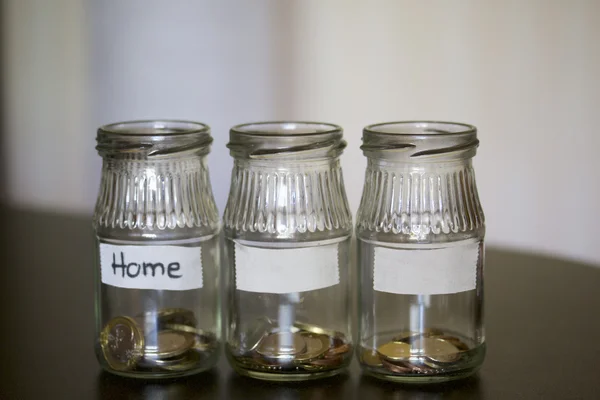 Three jars - piggy bank. In the miscellaneous expenses. They are glued to the tape to write her goal of spending. At the bottom poured a bit of coins. Budget Management.