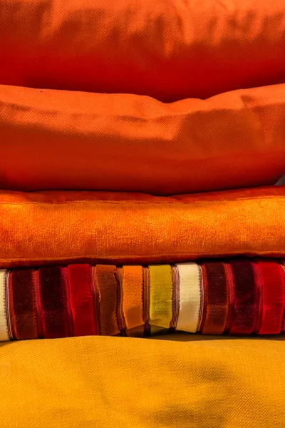 Yellow and orange colored pillows stacked on top of each other