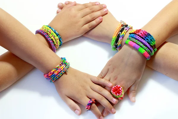 4 girl\'s hand with elastic and colorful rainbow loom bracelet on hands