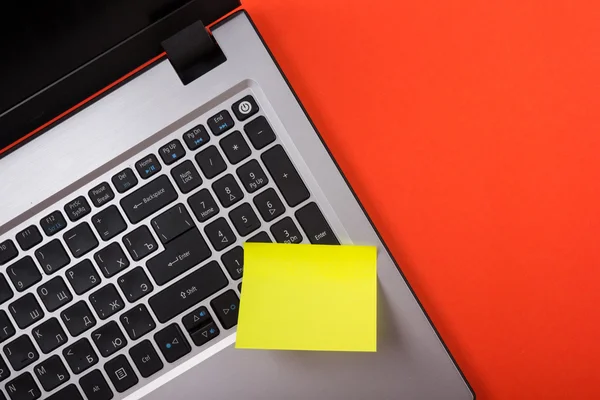 Office table desk with set of colorful supplies, white blank note pad, cup, pen, pc, crumpled paper, flower on red background. Top view and copy space for text