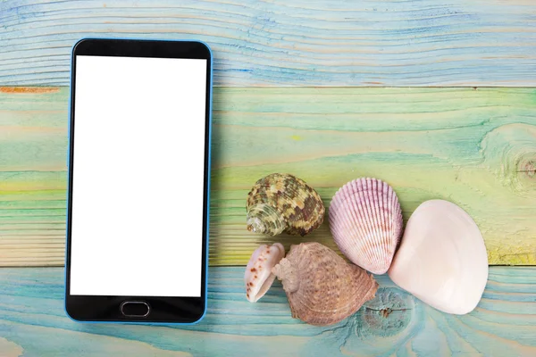Summer sea vacation mockup background. Blank screen mobile sell smartphone tablet pc page with Travel items on blue green wooden table. Sea shells, pebbles, top view.