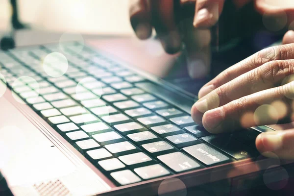 Mans hands typing on laptop keyboard. Double expo.