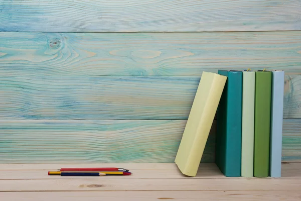 Back to school. Stack of colorful books on wooden table.