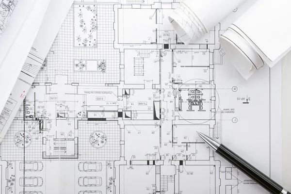 Architectural blueprints and blueprint rolls with magnifying gla